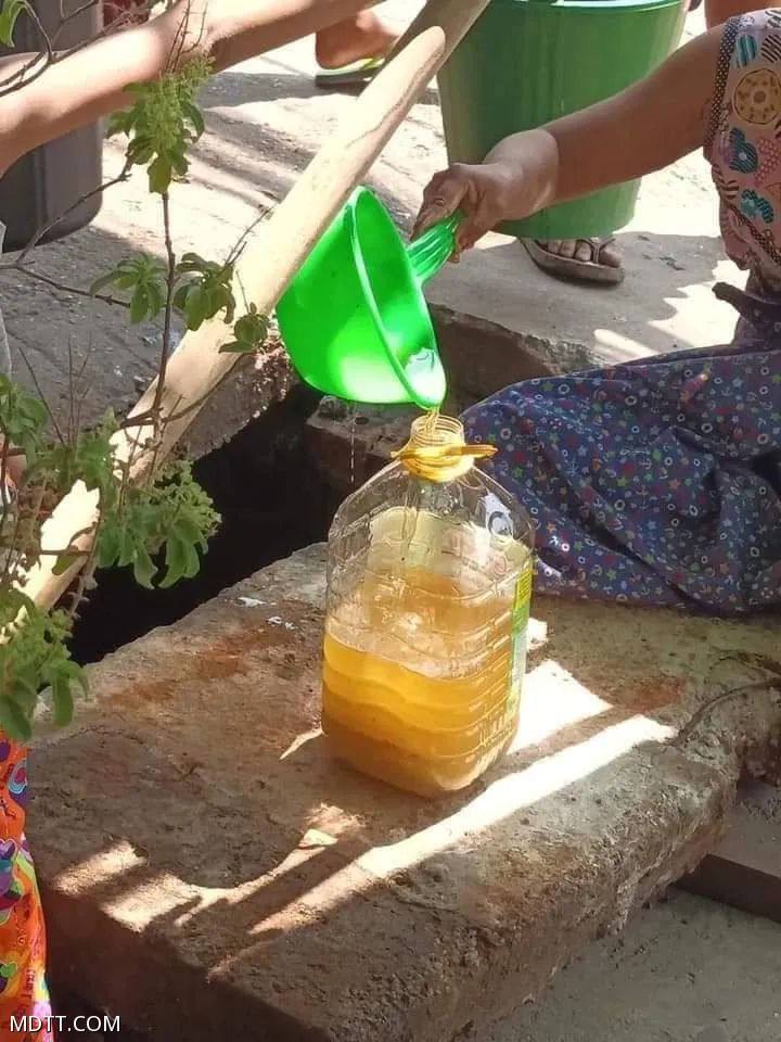 缅甸仰光储油池发生泄漏，民众争相在水沟内捞油